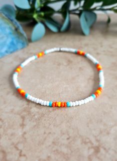 Sunrise Stretch Anklet This handcrafted white anklet features the bright orange and yellow colors you might see during a sunrise, along with the blue sky. >>Details: 1. Material: 8/0 (3mm) glass seed beads, stainless steel roundel 2. Color: Matte white, Czech opaque orange, frosted turquoise, and opaque yellow, stainless steel 3. Size: *Approximately 9.25 inches long 4. Clasp: Elastic cord >>Shipping: 1. Most orders are shipped same day or next day (weekdays only) via USPS First Class Mail. I do Blue And White Seed Bead Bracelet, Ombre Beaded Bracelet, Preppy Seed Bead Necklace, Handmade White Anklets For Summer, White Beaded Anklets For Summer, White Anklets For Summer Festivals, Bohemian Orange Friendship Bracelets For Vacation, Orange Bohemian Beaded Bracelets For Summer, Bohemian Orange Beaded Bracelets For Summer