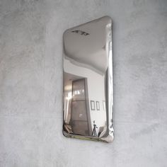 a bathroom mirror mounted to the side of a wall