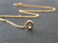 "A tiny matt gold plated initial letter 'O' pendant dangles from a fine gold plated chain necklace.  Simple and modern. Initial 'O' pendant is matt gold plated, double sided, tarnish resistant, size - 5 x 7mm Fine diamond cut chain necklace is gold plated, 15\" with 1.5\" extender chain, total 16.5\" chain. Other alphabet letters available - A-Z in gold and silver: Gold personalized initial necklace, choose your initial:- https://www.etsy.com/listing/129735775/tiny-initial-letter-matt-gold-necklace?ref=shop_home_active Silver personalized initial necklace, choose your initial:- https://www.etsy.com/listing/129735289/tiny-silver-initial-letter-necklace?ref=shop_home_active ★ All items arrive in a gift box with ribbon.  Ready to ship.  Personalized messages and direct shipping to the recipie O Necklace, Jewelry Bridesmaid, Letter O, Necklace Wedding, Gold Initial, Personalized Initials, Initial Letter, Letter Necklace, Initial Letters