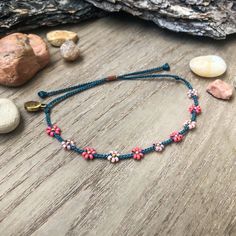 "Introducing my first \"Little Flower\" design! This color palette was inspired by blossoming trees. We see a lot of pinks on the trees around us in the spring, the sweet smells and soft petals on the ground that my kids will inevitably pick up. Happy colors!  This bracelet matches perfectly with the seed bead version, found here: https://colorsoftheprairie.etsy.com/listing/1451854024 Please keep in mind that even though I try my best to keep the spacing even between flowers, I'm not a machine and the spaces are not all perfectly equal. I think this adds to unique-ness and similarity to wild flowers in nature! They don't grow in straight lines! But if you are unhappy, please let me know ASAP and see my \"Happiness Guarantee\" down below. This listing is for 1 adjustable seed bead bracelet Pink Resizable Beaded Bracelets For Summer, Spring Bohemian Adjustable Beaded Bracelets, Adjustable Beaded Bracelets For Spring Festival, Summer Pink Resizable Beaded Bracelets, Bohemian Beaded Bracelets With Tiny Beads For Spring, Spring Bohemian Beaded Bracelets With Tiny Beads, Pink Beaded Bracelets For Spring Festival, Spring Festival Pink Beaded Bracelets, Adjustable Colorful Beads Friendship Bracelets For Spring