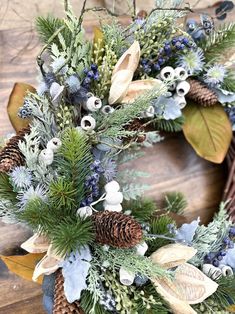 a wreath with pine cones and blue berries