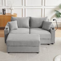 a gray couch sitting on top of a white rug