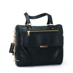 a black handbag with gold zippers on the front and shoulder straps, sitting against a white background