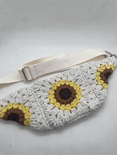 a crocheted purse with sunflowers on the front and bottom, sitting on a white surface