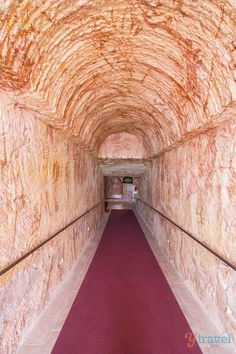 a long tunnel with red carpet and white walls