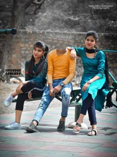 three people sitting on a bench in the park