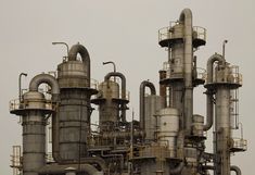 an industrial plant with many pipes and pips on it's sides, against a gray sky