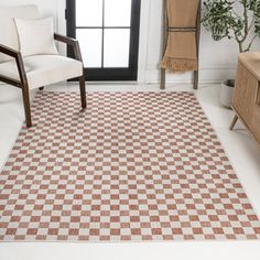 a brown and white checkered area rug in a living room with a chair, coffee table and window