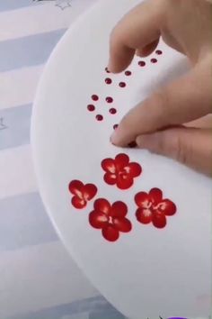 someone is drawing flowers on paper with a marker