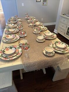 the table is set with many plates and place settings