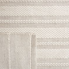 the textured fabric is white and grey with stripes on it, as well as an area rug