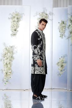 This black sherwani set features all over white dori embroidery on a thick matka silk base. This ensemble is paired with a black cotton silk kurta and a silk salwar. Completing footwear is also available.From Seema Gujral's Tuscan Summer collection. DELIVERY TIMEPlease allow 4 months for your outfit to arrive.FABRIC DETAILSThick Matka silkProfessional cleaning only. Festive Black Semi-stitched Bandhgala, Designer Embroidered Silk Sherwani, Designer Silk Sherwani For Festive Occasions, Silk Sherwani With Traditional Drape For Ceremonial Occasions, Designer Silk Sherwani For Eid, Silk Sherwani Straight Kurta For Formal Occasions, Formal Silk Sherwani With Chikankari Embroidery, Black Raw Silk Traditional Wear With Zari Work, Elegant Black Raw Silk Traditional Wear