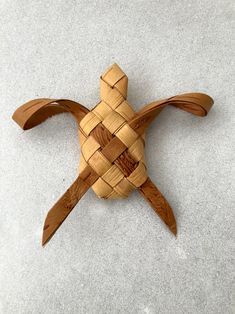 a wooden turtle made out of wood with braiding around it's back end