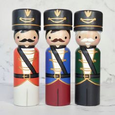 three wooden nutcrackers are standing next to each other on a marble surface