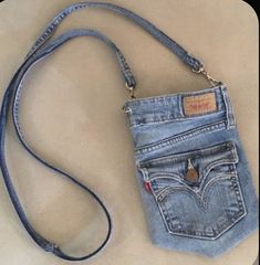 a cell phone is in the pocket of a jean purse that's attached to a strap