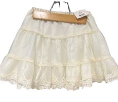 Get ready to twirl in this beautiful ivory flouncy skirt from Hanna Anderson! Made with an elastic waistband for a comfortable fit, this skirt is perfect for any party occasion. The delicate lace trim adds a touch of elegance to this Anderson piece. This skirt is brand new with tags and is a size 120/6 in US sizes. The skirt is part of the Girls' Clothing collection from Hanna Anderson. It is lined and comfortable. Don't miss out on adding this stunning piece to your little girl's wardrobe! Summer Party Cream Skirt, Party Skirt With Cream Lace Trim, Party Skirt With Cream Color And Lace Trim, Cream Party Skirt With Lace Trim, Casual Cream Party Skirt, Flouncy Skirt, Hanna Anderson, Party Skirt, Girls Wardrobe