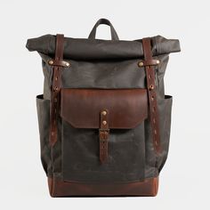 a brown and black backpack with two straps on the front, one has a leather pocket