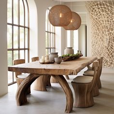 a wooden table surrounded by chairs and vases