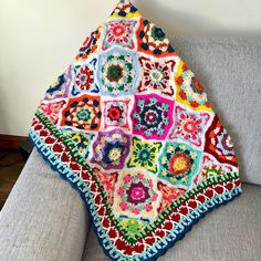 a crocheted granny blanket sitting on top of a couch