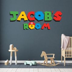 a child's room with toys on the floor and in the wall that says jacob's room