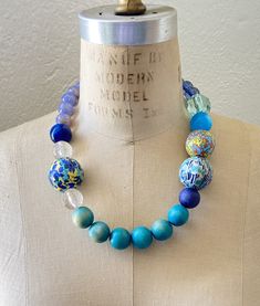 Classic Queen mum in updated palette and with handmade decoupage beads covered in vintage prints Blue Jewelry With Wooden Beads, Elegant Blue Jewelry With Wooden Beads, Blue Artisan Necklace With Large Beads, Artisan Blue Necklace With Large Beads, Adjustable Blue Necklace With Wooden Beads, Blue Bohemian Wooden Beads Necklaces, Artisan Blue Beaded Necklaces, Blue Large Beads Necklace, Unique Blue Wooden Beaded Necklaces