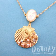 - Description - Details Accessorize like a mermaid would with this beautiful necklace featuring a seashell pendant covered in starfishes, pearls and rhinestones in gold! Store FAQ | Shipping Info | Returns & Exchanges Size: The seashell pendant measures 3 cm tall by 3.5 cm wide and hangs on a 32 inch long chain that can be adjusted with a lobster clasp! Material: Gold Plated Tin Alloy, Pearl Beads, Rhinestones Animal Jewelry by DOTOLY Gold Seashell Necklace, Sunrise Shell, Sea Life Jewelry, Gold Mermaid, Life Jewelry, Seashell Pendants, Marcasite Jewelry, Mermaid Jewelry, Seashell Necklace