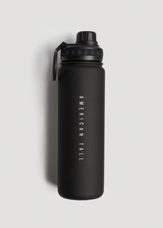 a black water bottle sitting on top of a white wall