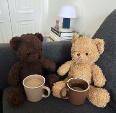 two teddy bears sitting on a couch with coffee