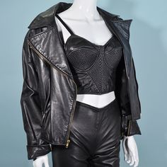 "Vintage 80s soft black leather motorcycle jacket. Zippers up the front, on the pockets, and wrist. Loose fit, wide shoulders. **Purple studded belt is NOT included in this sale. It is for styling purposes only. LABEL: Cache SIZE: All sizing given is approximate. Refer to measurements for an accurate fit. Shoulder: 20\" Underarm: 22\" double to 44\" Sleeve: 22 1/2\" Waist: 17 1/2\" double to 35\" Length: 21\" Mannequin measurements: Size 2, Bust - 33\" Waist - 24\" Hips - 34\" CONDITION: Very go Edgy Biker Jacket With Zipper For Alternative Fashion, Edgy Rivets Biker Jacket For Night Out, Edgy Biker Jacket With Rivets For Night Out, Rocker Fitted Biker Jacket For Alternative Fashion, Punk Style Fitted Leather Jacket For Concerts, Fitted Leather Jacket With Rivets For Concerts, Fitted Rivets Biker Jacket For Concerts, Fitted Biker Jacket With Rivets For Concerts, Fitted Moto Biker Jacket For Alternative Fashion