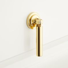 a gold door handle on a white wall