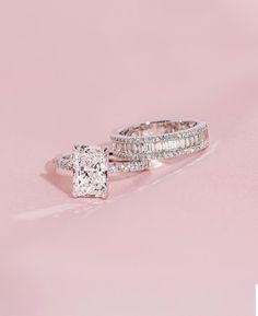 two wedding rings on pink background