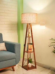 a living room with a blue chair and a wooden shelf next to a plant on the floor