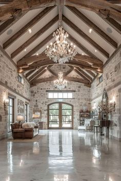 a large living room with stone walls and vaulted ceiling, chandelier hanging from the ceiling