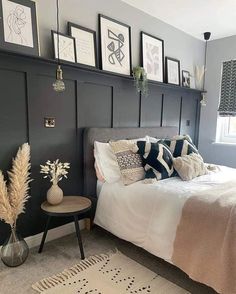 a bedroom with gray walls and pictures on the wall