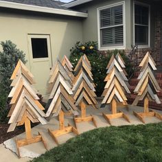 several wooden christmas trees sitting in front of a house