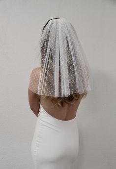 the back of a woman's head wearing a white veil with polka dots on it