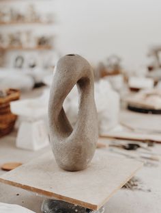 a sculpture sitting on top of a table next to other pieces of art and furniture