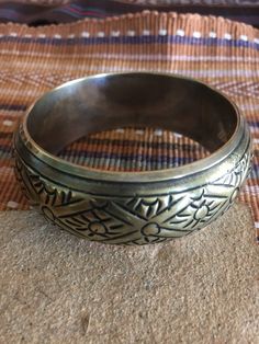 Vintage brass bracelet has silver plating on inside and over edge. Beautiful tribal design will look nice to offset black attire or blend well with Southwest or other ethnic clothes. Inside of bangle measures 8 inches around. It is 1 1/4 inch wide and about 1/2 inch high. A fun boho vintage bracelet. Would make an unique gift. Metal Bangle With Intricate Design For Festival, Gold Bohemian Bracelets For Rituals, Bohemian Metal Bracelets With Antique Finish, Bohemian Metal Bracelet With Antique Finish, Bohemian Gold Engraved Bracelets, Bohemian Antique Gold Brass Bracelets, Bohemian Gold Engraved Bracelet, Festival Brass Bangle Cuff Bracelet, Festival Brass Cuff Bangle Bracelet