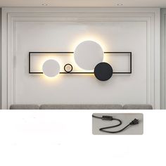 a white wall with three circular lights on it and a black cord attached to the wall