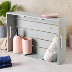 a bathroom shelf with two soap dispensers and a towel rack on it