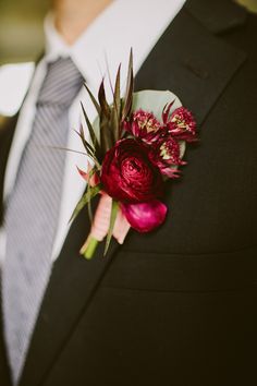 a man wearing a suit and tie with flowers on it's lapel flower