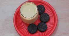 an oreo cookies and milk are on a red plate next to a glass of milk