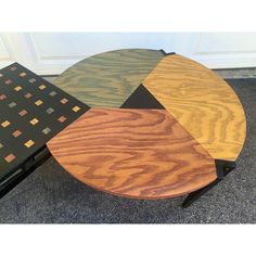 three tables with different colors and shapes on top of each other in front of a door