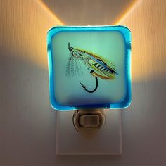 a light that is on the side of a wall with a fishing lure painted on it