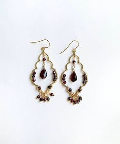 Chandelier earrings that highlight the lovely garnet gemstone. These earrings are inspired by Moroccan patterns and motifs that are captivating. Elegant Red Chandelier Earrings With Intricate Design, Elegant Garnet Teardrop Earrings, Elegant Garnet Earrings, Elegant Gold Garnet Earrings, Garnet Gemstone Drop Earrings, Elegant Garnet Drop Earrings, Elegant Ruby Chandelier Earrings For Festive Occasions, Elegant Pierced Garnet Earrings, Elegant Teardrop Chandelier Earrings With Gemstone Accents