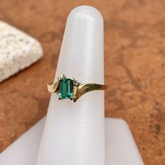 Estate/ vintage polished 10KT yellow gold ring with center, lab-created emerald + surrounding white diamonds. Timeless gold ring with a beautiful, vibrant green emerald! Size 7.25 Can be resized for an additional fee Weight: 1.8g (2) 1 pt genuine, white diamonds; SI clarity; H color Approx. 6mm x 4mm lab-created, green, rectangle center emerald Excellent estate condition Emerald Diamond Ring, Lab Created Emerald, Yellow Gold Ring, Vibrant Green, Green Emerald, Emerald Diamond, White Diamonds, Yellow Gold Rings, Ring Holder