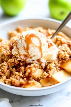 an apple crisp with ice cream and caramel drizzle on top in a bowl