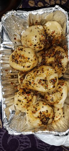 some kind of food that is sitting on tin foil in a pan with seasoning