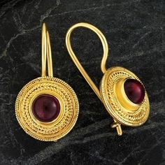 Handcrafted of a tiny disc of filigree thread, this classic Greek design highlights the beauty of a single cabochon garnet. The original Greek earrings are part of the Museum's permanent collection. 24k gold over sterling silver. Hinged backs for pierced ears. Size: 7/8 Inches. Gold Cabochon Brass Earrings, Gold Brass Earrings With Cabochon Detail, Gold Brass Cabochon Earrings, Elegant Gold Round Pendant Earrings, Yellow Gold Cabochon Earrings, Yellow Gold Cabochon Round Earrings, Gold Round Pendant Earrings For Formal Occasions, Gold Round Pendant Earrings For Formal Events, Yellow Gold Round Cabochon Earrings