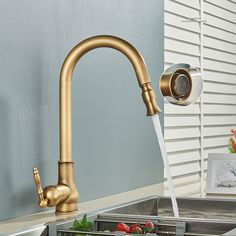 a kitchen faucet with water running from it's spout and vegetables in the sink